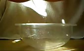 Sexy girl peeing in a glass bowl