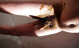 Rubbing brown poop on his long cock
