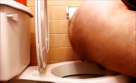 Hairy guy pooping in the toilet