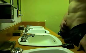 guy takes a piss in the bathroom over the sink