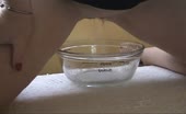 Piss fills measuring cup as she squats over it