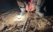 Piss streams between boots on dirt at night